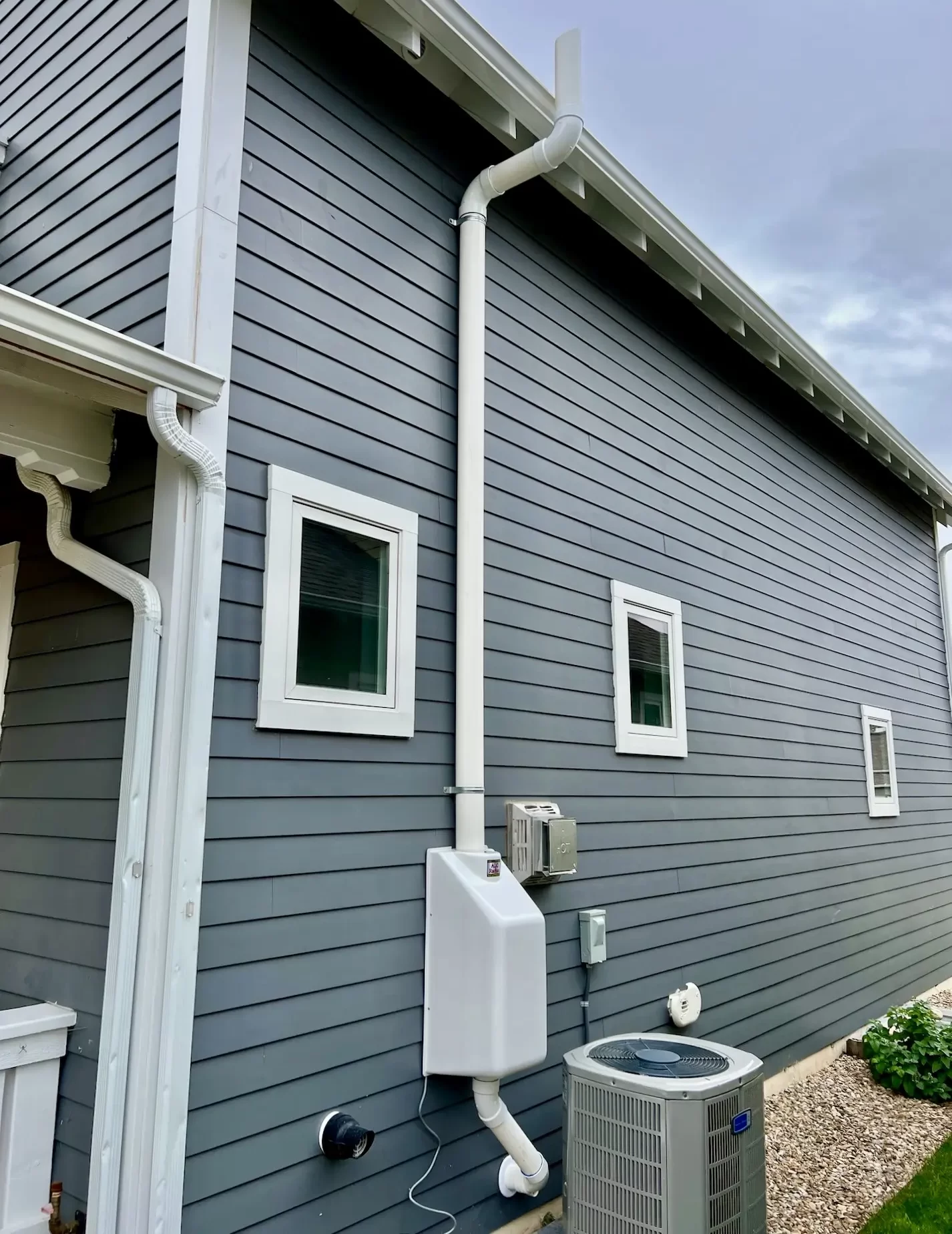 Clean exterior radon mitigation system installed on a Black Hills home.