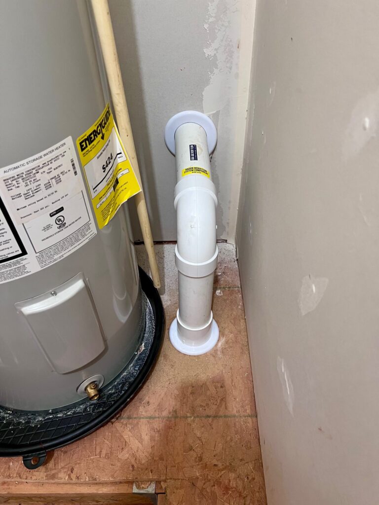 Radon mitigation suction point and sealed PVC pipe installation in a Spearfish, South Dakota home.